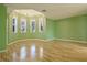 Light green bedroom with wood floors and bay windows at 510 Wideview Ave, Tarpon Springs, FL 34689