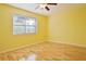 Yellow bedroom with wood floors and a large window at 510 Wideview Ave, Tarpon Springs, FL 34689