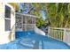 Blue deck with white railing overlooking pool and tropical landscaping at 510 Wideview Ave, Tarpon Springs, FL 34689