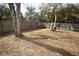 A large backyard with mature trees and a wooden fence at 9834 Miramar St, New Port Richey, FL 34654