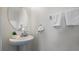 This half bathroom offers a modern sink and faucet, alongside white towels and an attractive, oval mirror at 12843 Buffalo Run Dr, Gibsonton, FL 33534