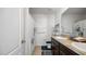 Bathroom with double sink vanity, shower with curtain, and white door at 12843 Buffalo Run Dr, Gibsonton, FL 33534