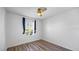 Bedroom with wood floor, ceiling fan, and window with blue curtains at 12843 Buffalo Run Dr, Gibsonton, FL 33534