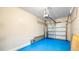 Garage with blue painted floor and automatic door opener at 12843 Buffalo Run Dr, Gibsonton, FL 33534