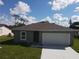 Newly constructed one-story home with gray exterior and driveway at 1378 Wilmette St, Port Charlotte, FL 33980
