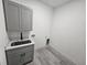Laundry room with gray cabinets and stainless steel sink at 1378 Wilmette St, Port Charlotte, FL 33980