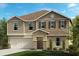 Two-story home with beige siding and three-car garage at 37496 Williamette Way, Zephyrhills, FL 33540