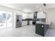 Modern kitchen features stainless steel appliances, gray backsplash, granite countertops, and an island at 5316 Altoona St, Sarasota, FL 34232
