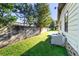 View of the backyard with green grass and a concrete wall at 35935 Tanda Cir, Zephyrhills, FL 33541