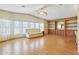 Spacious living room featuring hardwood floors, built-in shelving, and large windows at 35935 Tanda Cir, Zephyrhills, FL 33541