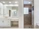 Bright bathroom with double sinks, a large mirror, and a walk-in shower at 18065 Wing Ave, Port Charlotte, FL 33948