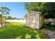 Tan shed in backyard with white vinyl siding at 12377 Fillmore St, Spring Hill, FL 34609