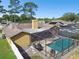 An elevated view of a home's backyard featuring a screened-in pool and stone patio at 12377 Fillmore St, Spring Hill, FL 34609