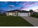 One story home with a two car garage, curb appeal, and landscaped lawn at 3841 San Pedro Ave, North Port, FL 34288