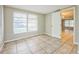 Bright bedroom featuring tile floors and neutral walls, with an open doorway leading to additional rooms at 10226 Willow Dr, Port Richey, FL 34668