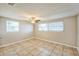 Bright, airy bedroom featuring tile floors, neutral walls, and natural light from two windows at 10226 Willow Dr, Port Richey, FL 34668