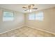 Bright bedroom featuring tile floors, neutral walls, and natural light from two windows with blinds at 10226 Willow Dr, Port Richey, FL 34668