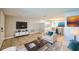 Open-concept living space featuring tile floors, neutral decor, a modern entertainment center, and a dining area at 10226 Willow Dr, Port Richey, FL 34668