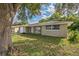 House with a large tree in the front yard at 10226 Willow Dr, Port Richey, FL 34668