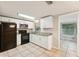 Bright kitchen with white cabinets, granite countertops, and black appliances at 10226 Willow Dr, Port Richey, FL 34668