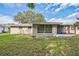 Rear view of house with screened porch and yard at 10226 Willow Dr, Port Richey, FL 34668