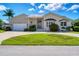 Tan house with a large garage and manicured lawn at 265 Belvedere Ct, Punta Gorda, FL 33950