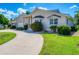 Tan house exterior, landscaped yard, and a curved driveway at 265 Belvedere Ct, Punta Gorda, FL 33950