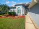 Gray house with palm trees, red mulch, and walkway at 3943 Chaucer Way, Land O Lakes, FL 34639