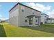 Backyard view of a two-story home with covered patio and ample green space at 168 Lazy Shore Dr, Nokomis, FL 34275
