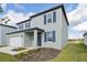 Two-story home with light gray siding, blue shutters, landscaping, and attached garage at 168 Lazy Shore Dr, Nokomis, FL 34275