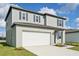 Two-story house with gray siding, white garage, and landscaping at 168 Lazy Shore Dr, Nokomis, FL 34275