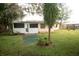 Backyard view showing house, screened porch and green space at 7224 Spring Hill Dr, Spring Hill, FL 34606