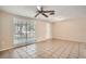 Living room with large window, tile floor, and ceiling fan at 8402 Mill Creek Ln, Hudson, FL 34667