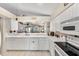 White kitchen with stainless steel appliances and breakfast bar at 7319 Eleanor Cir, Sarasota, FL 34243