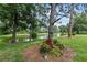 Landscaped backyard with pond view, lush foliage, and mature trees at 7319 Eleanor Cir, Sarasota, FL 34243