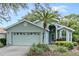 Single-story home with light green exterior, two car garage, and palm tree at 7319 Eleanor Cir, Sarasota, FL 34243