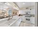 White kitchen with breakfast bar, stainless steel appliances, and view of dining area at 7319 Eleanor Cir, Sarasota, FL 34243