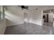 A brightly lit living room flows to the kitchen with neutral paint and gray flooring at 4652 Alma St, New Port Richey, FL 34652