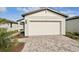 New construction home with white garage door and paver driveway at 113 Whiteland Bnd, Nokomis, FL 34275