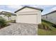Front view of house with white garage door and paver driveway at 113 Whiteland Bnd, Nokomis, FL 34275
