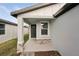 Covered front porch with stone accents and gray door at 113 Whiteland Bnd, Nokomis, FL 34275