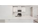 Modern kitchen with white cabinets, large island, and stainless steel appliances at 113 Whiteland Bnd, Nokomis, FL 34275
