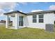 Rear exterior view showcasing patio, AC unit, and lawn at 456 Lazy Shore Dr, Nokomis, FL 34275