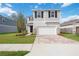 Two-story home with a two-car garage, paver driveway, stone accents, and well-maintained lawn at 37545 Mackenzie Dr, Zephyrhills, FL 33540