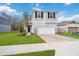Two-story home featuring a two-car garage, paver driveway, stone accents, and manicured lawn at 37545 Mackenzie Dr, Zephyrhills, FL 33540