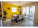 Dining area with yellow accent wall and sliding glass doors to patio at 8493 Hardy Bay Loop, Wesley Chapel, FL 33545