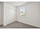 Bright bedroom with gray carpet, window, and double door closet at 164 Lazy Shore Dr, Nokomis, FL 34275