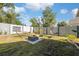 Spacious backyard with a fire pit, patio furniture, a manicured lawn, and white fence at 7940 Fashion Loop, New Port Richey, FL 34654