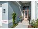 Close up of front entryway with a decorative front door and colorful potted plants at 7940 Fashion Loop, New Port Richey, FL 34654
