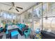 Bright enclosed patio featuring a ceiling fan, tile floors, comfortable seating, and natural lighting at 7940 Fashion Loop, New Port Richey, FL 34654